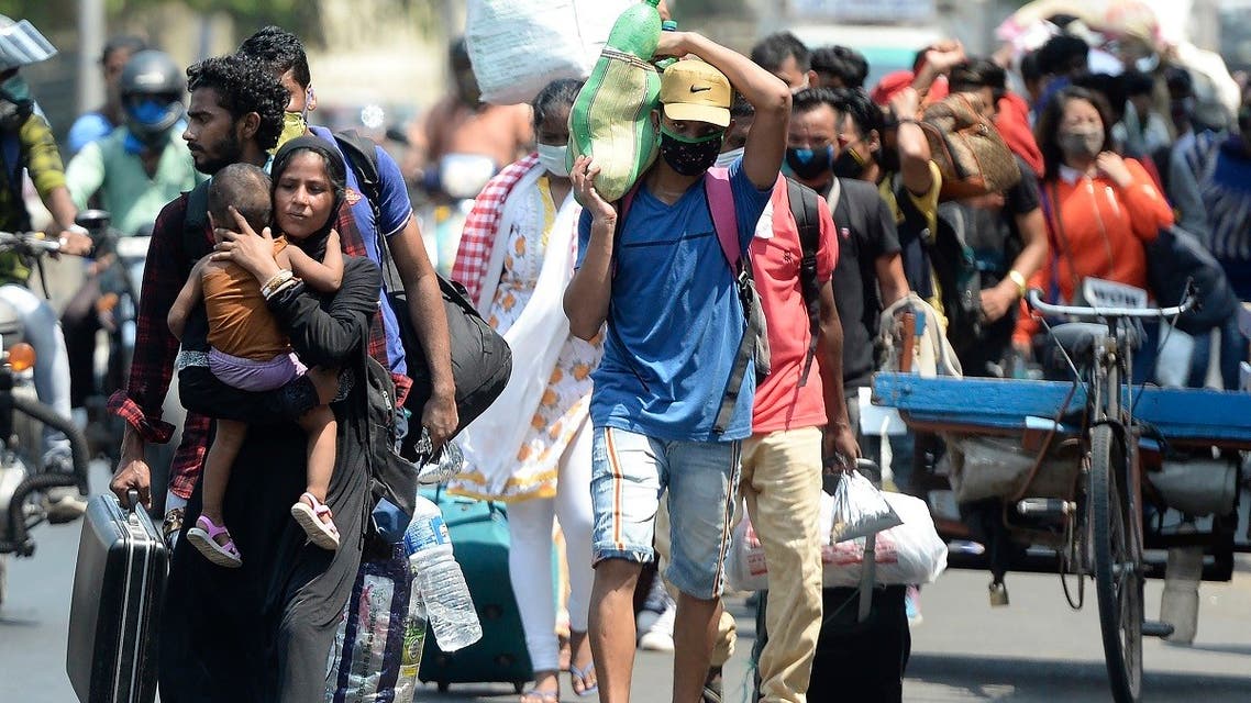 Stranded migrant laborers walk to an assembling center to get transferred to a railway station to travel to Bihar after the government eased a nationwide lockdown, in Chennai on May 30, 2020. (AFP)