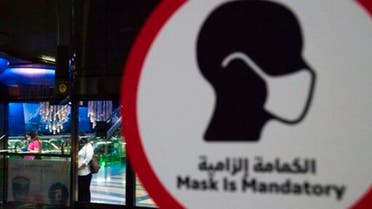 A commuter wearing a mask and disposable gloves due to the coronavirus pandemic waits for the driverless Metro at a station in Dubai, United Arab Emirates, Sunday, April 26, 2020. (AP)