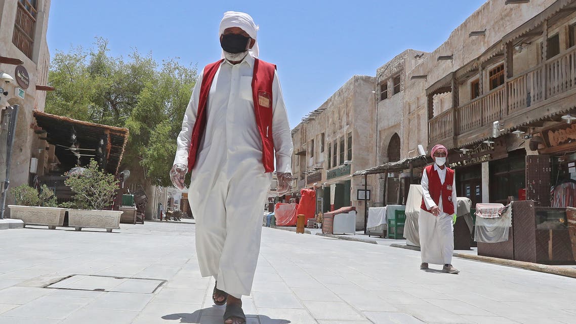 Members of staff wearing masks walk by at Qatar's touristic Souq Waqif bazar in the capital Doha, on May 17, 2020. (AFP)