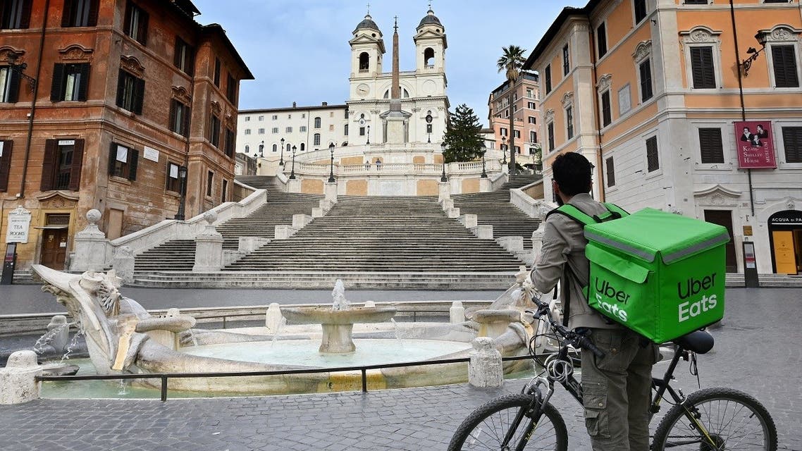 An Uber Eats delivery man stands by the Spanish Steps at a deserted Piazza di Spagna in central Rome on March 12, 2020. (AFP)