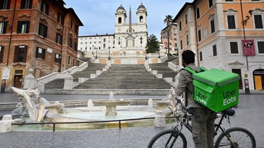 An Uber Eats delivery man stands by the Spanish Steps at a deserted Piazza di Spagna in central Rome on March 12, 2020. (AFP)