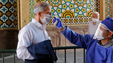 An Iranian official checks the temperature of visitors at the Shah Abdol-Azim shrine in the capital Tehran on May 25, 2020, following the reopening of major Shiite shrines across the Islamic republic, more than two months after they were closed because of the Middle East's deadliest novel coronavirus outbreak. 