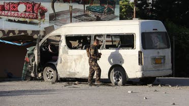 An Afghan security personnel investigates a damaged vehicle carrying employees of Khurshid TV along a roadside, at the site of a bomb blast in Kabul on May 30,2020. 