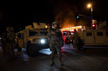 Members of the National Guard hold a perimeter as a fire crew works to put out a fire at a gas station on Lake Street on May 29, 2020 in Minneapolis, Minnesota. (AFP)