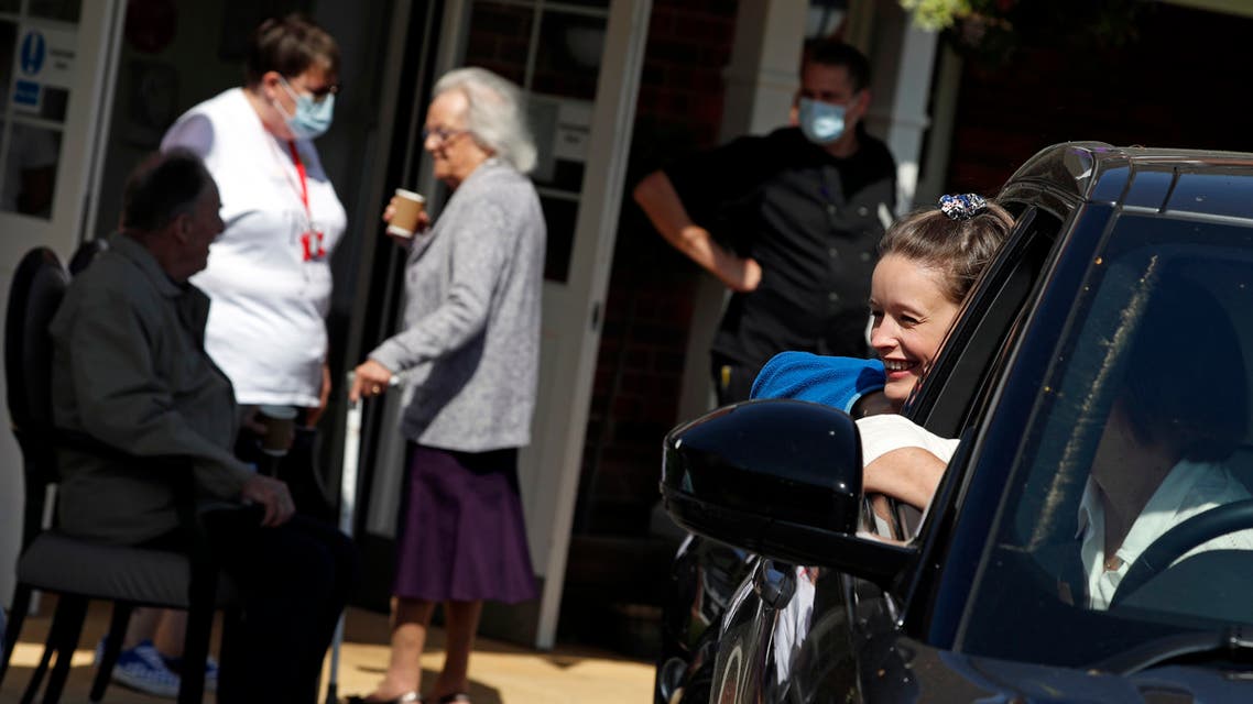 A girl talks with her grandmother Barbara Webster (not seen) from her car window during a drive-through visit to Gracewell, a residential care home in Adderbury near Banbury, west of London on May 28, 2020, during the COVID-19 pandemic. Relatives and friends were able to see the elderly residents at Gracewell for the first time since Coronavirus pandemic lockdown started in early March.