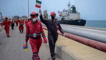 A worker of the Venezuelan state oil company PDVSA waves an Iranian flag as the Iranian-flagged oil tanker Fortune docks at the El Palito refinery in Puerto Cabello, in the northern state of Carabobo, Venezuela, on May 25, 2020. (AFP)