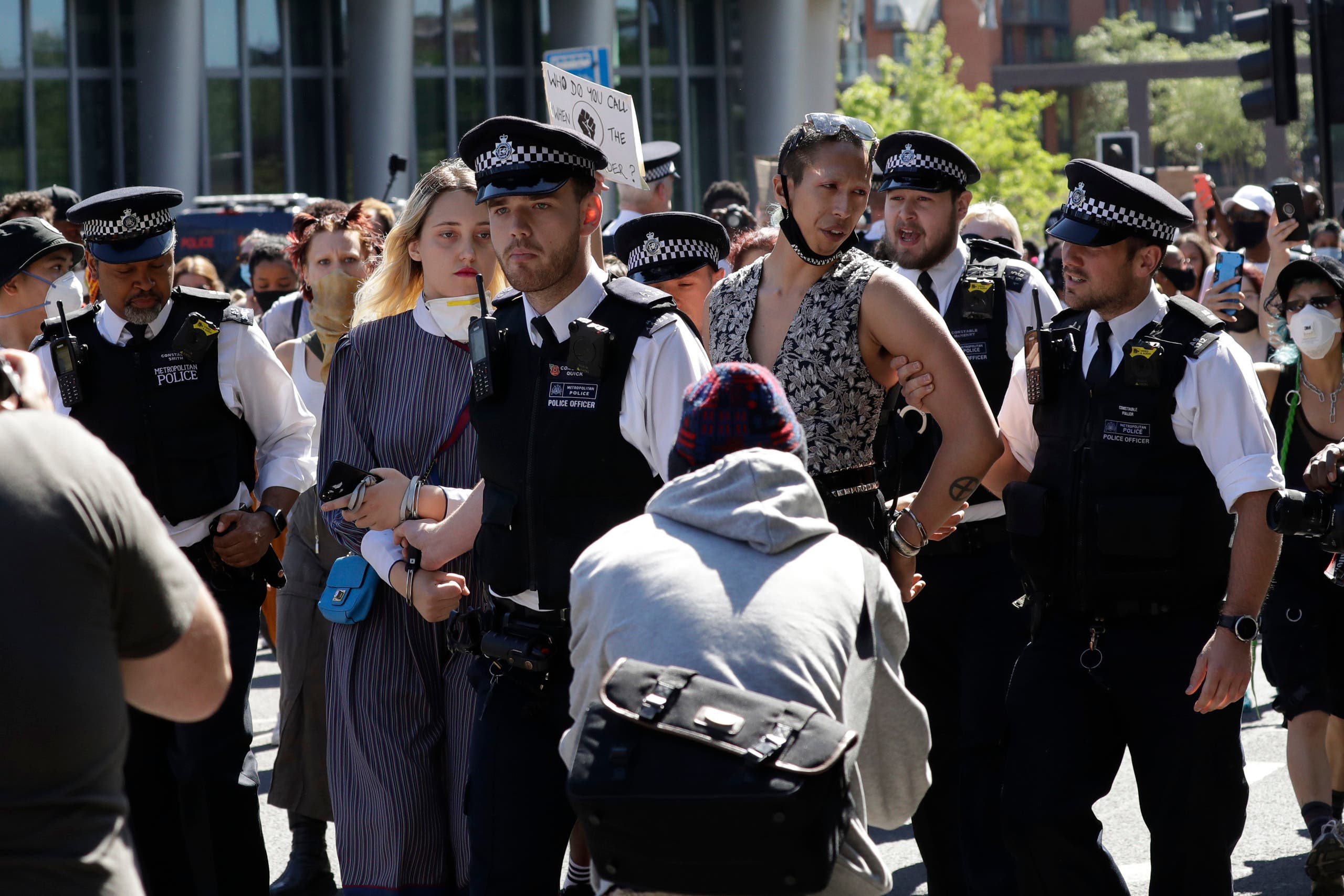 Police officers remove two protesters they handcuffed from outside the US embassy after people marched there from Trafalgar Square in central London on May 31, 2020, to protest against the recent killing of George Floyd in Minneapolis, USA. (AP)