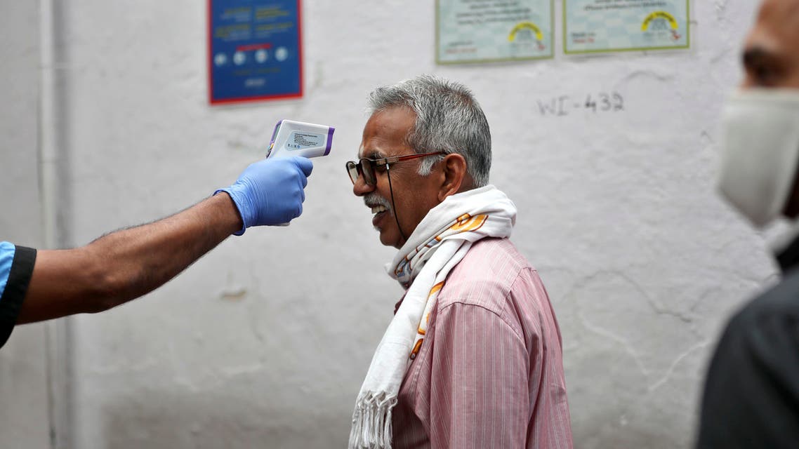An elderly Indian reacts as a staff member checks his body temperature before allowing him into an eatery in Bengaluru, India, Saturday, May 30, 2020. (AP)