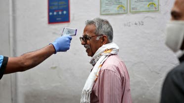 An elderly Indian reacts as a staff member checks his body temperature before allowing him into an eatery in Bengaluru, India, Saturday, May 30, 2020. (AP)