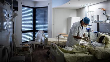 French surgeon Maurice Mimoun chats with a patient at the plastic surgery unit of Saint-Louis hospital of the AP-HP (Assistance Publique - Hopitaux de Paris) in Paris on May 28, 2020 as France eases lockdown measures taken to curb the spread of the COVID-19 (the novel coronavirus). 