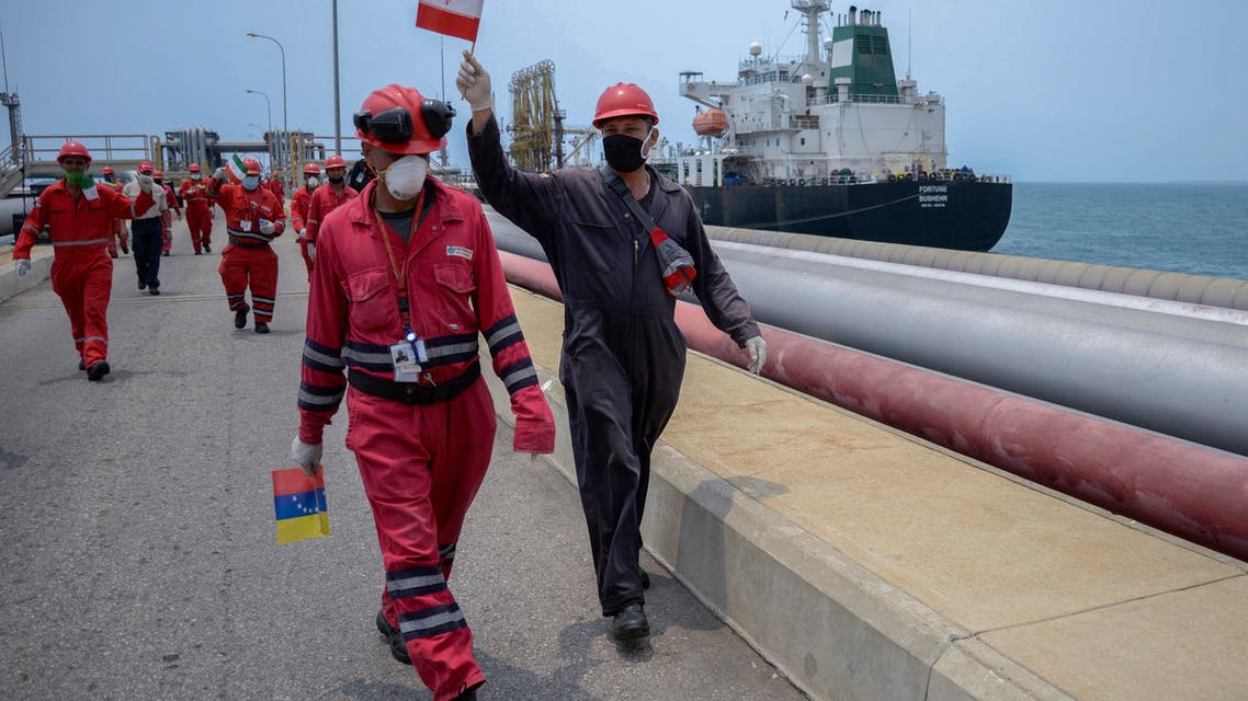 A worker of the Venezuelan state oil company PDVSA waves an Iranian flag as the Iranian-flagged oil tanker Fortune docks at the El Palito refinery in Puerto Cabello, in the northern state of Carabobo, Venezuela, on May 25, 2020. (AFP)