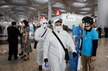 An employee wearing a thermal imaging VF helmet monitors passengers at the entrance of Istanbul Airport, in Istanbul, Turkey June 1, 2020. (Reuters)