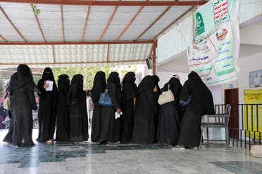 Women stand in line to get food vouchers at a World Food Programme food aid distribution center in Sanaa, Yemen February 11, 2020. (Reuters)