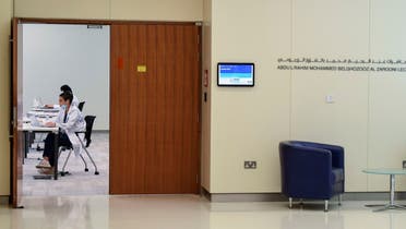 A man wearing a protective mask sits outside a hall where operators man their posts at Dubai's COVID-19 Command and Control Centre at Mohammed bin Rashid University. (AFP)