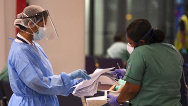 A member of an Indian medical team registers upon her arrival at Dubai International Airport on May 9, 2020, to help with the coronavirus (COVID-19) pandemic. (AFP)
