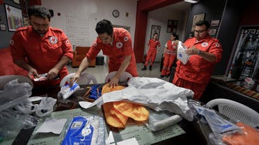 Members of the Lebanese Red Cross arrange their protective outfits in Beirut on May 29, 2020, during the novel coronavirus pandemic crisis. (AFP)