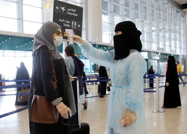 A security woman checks the temperature of a woman at Riyadh International Airport. (File photo: Reuters)