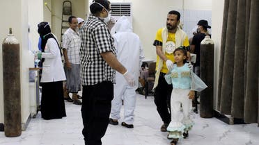 In this May 12, 2020 photo, Yemeni medical workers wearing masks and protective gear talk to patients at hospital in Aden, Yemen. People have been dying by the dozens each day in southern Yemen's main city, Aden, many of them with breathing difficulties, say city officials. Blinded with little capacity to test, health workers fear the coronavirus is running out of control, feeding off a civil war that has completely broken down the country. (AP Photo/Wail al-Qubaty)