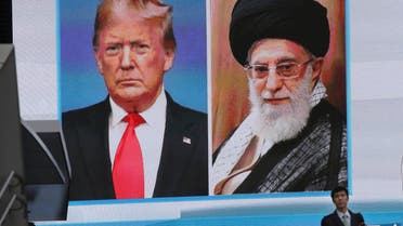 A man walks by a huge screen showing U.S. President Donald Trump, left, and Iranian Supreme Leader Ayatollah Ali Khamenei, in Tokyo, Wednesday, Jan. 8, 2020. (AP)