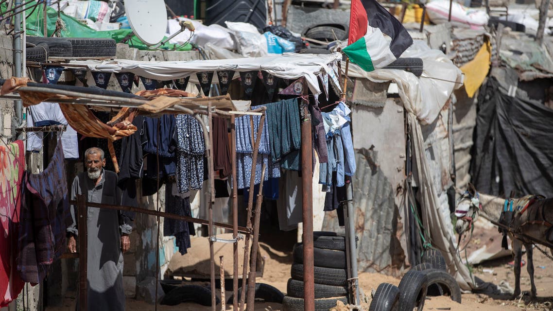 A Palestinian stands among hanging clothes in a slum on the outskirts of Khan Younis Refugee Camp, in the southern Gaza Strip on June 1, 2020. (AP)