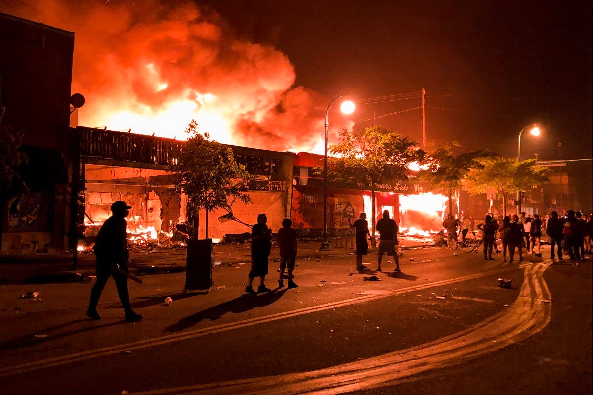 Flames rise from a liquor store and shops near the Third Police Precinct on May 28, 2020 in Minneapolis, Minnesota, during a protest over the death of George Floyd. (AFP)