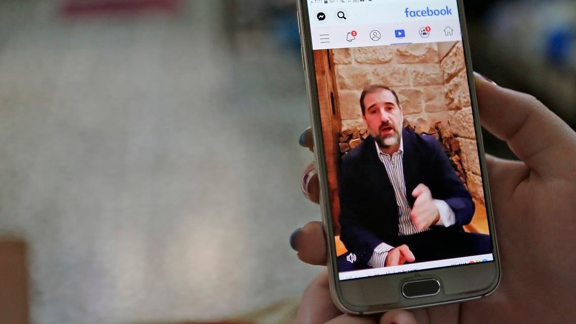 A woman watches the Facebook video of Syrian businessman Rami Makhlouf on her mobile in Syria's capital Damascus. (AFP)