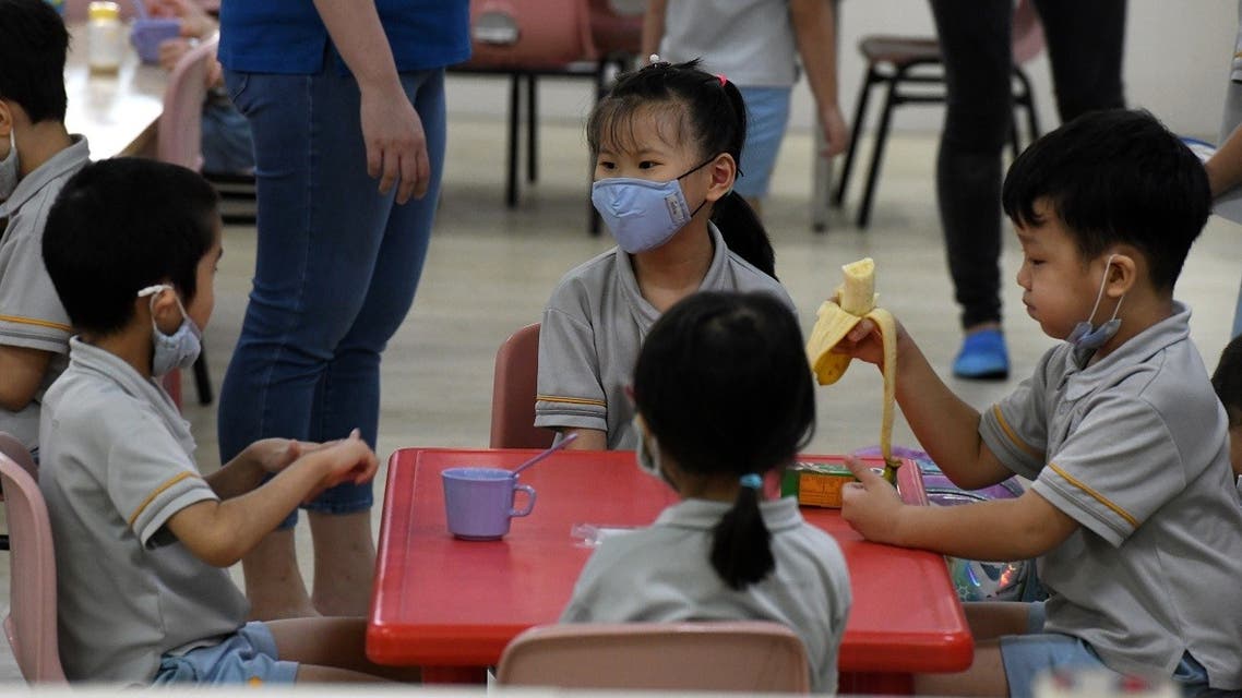 Pre-school children gather around a table inside their classroom as schools reopened in Singapore on June 2, 2020. (AFP)