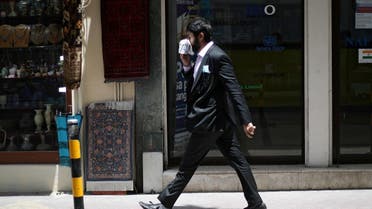 A man uses a cloth as a face mask following the outbreak of Coronavirus disease (COVID-19), as he walks in a central souq ahead of the holy month of Ramadan in Manama, Bahrain, April 23, 2020. (Reuters)