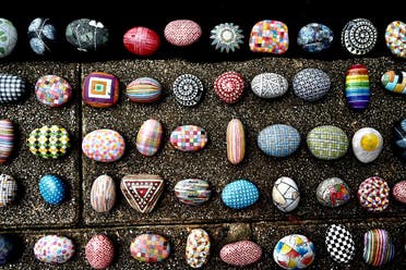 colourfully painted stones painted by artist Wu Rong-bi, also as know as “Uncle Stone,” on display along a street in Taipei. (AFP)
