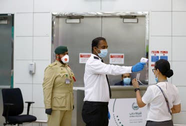 A security man takes temperature of a woman at Dubai International Airport. (File photo: Reuters)
