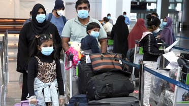 Members of an Indian family check in at the Muscat International Airport before leaving the Omani capital on a flight to return to their country, on May 9, 2020, amid the novel coronvirus pandemic crisis. India has been bringing home hundreds of thousands of its citizens stuck abroad after it banned all incoming international flights in late March in a bid to control the coronavirus crisis, leaving vast numbers of workers and students stranded.