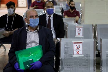 People wearing protective face masks wait to complete their transactions in the Civil Status Department after Jordan's public sector employees returned gradually to work. (Reuters)