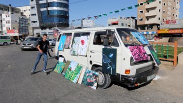 A boy rollerblades past an art-van with paintings put on sale by Palestinian artists, amid the coronavirus disease (COVID-19) spread, in the southern Gaza Strip May 30, 2020. (Reuters)