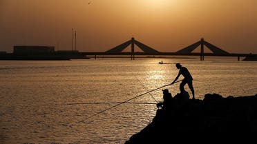 People fish during the sun set, following the outbreak of the coronavirus disease (COVID-19), in Manama. (Reuters)