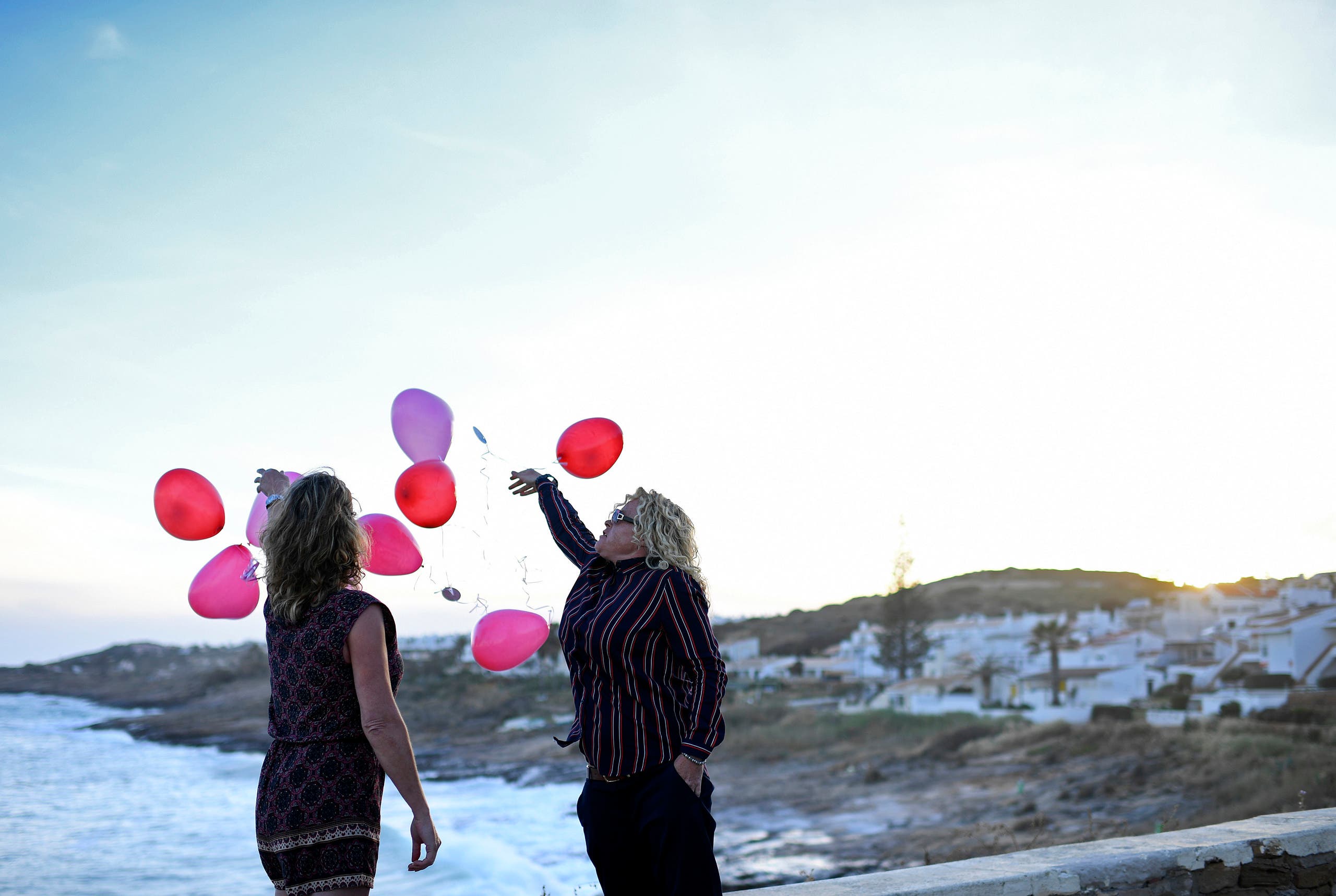 Two people release baloons in Praia da Luz, near Lagos, to mark the 10th anniversary of the dissapearance of British child Madeleine McCann on May 3, 2017. (AFP)