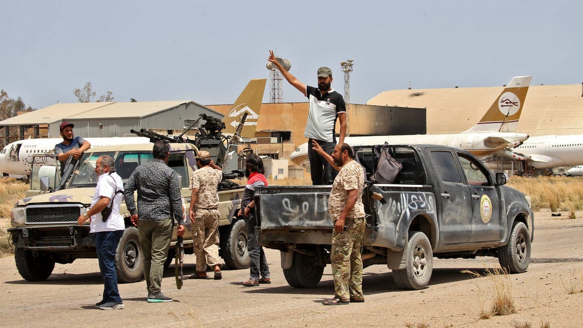 Fighters loyal to the UN-recognised Libyan Government of National Accord (GNA) stand outside a technical (pickup truck mounted with turret) at Tripoli International Airport, on the southern outskirts of the Libyan capital Tripoli on June 4, 2020, after the complex was taken over by pro-GNA forces following clashes with rival forces loyal to strongman Khalifa Haftar. The GNA said on June 4 that it was back in full control of the capital and its suburbs after more than a year of fighting off an offensive by eastern strongman Khalifa Haftar. The announcement came after GNA forces retook the capital's civilian airport the previous day, more than a year after losing it in Haftar's initial drive on the capital.