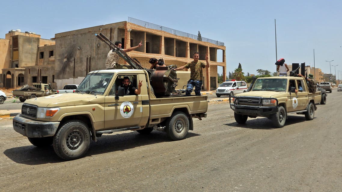 Fighters loyal to the UN-recognised Libyan Government of National Accord (GNA) stand outside a technical (pickup truck mounted with turret) at Tripoli International Airport, on the southern outskirts of the Libyan capital Tripoli on June 4, 2020, after the complex was taken over by pro-GNA forces following clashes with rival forces loyal to strongman Khalifa Haftar. The GNA said on June 4 that it was back in full control of the capital and its suburbs after more than a year of fighting off an offensive by eastern strongman Khalifa Haftar. The announcement came after GNA forces retook the capital's civilian airport the previous day, more than a year after losing it in Haftar's initial drive on the capital.