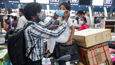 Members of an Indian family check in at the Muscat International Airport before leaving the Omani capital on a flight to return to their country, on May 9, 2020, amid the novel coronvirus pandemic crisis. India has been bringing home hundreds of thousands of its citizens stuck abroad after it banned all incoming international flights in late March in a bid to control the coronavirus crisis, leaving vast numbers of workers and students stranded.