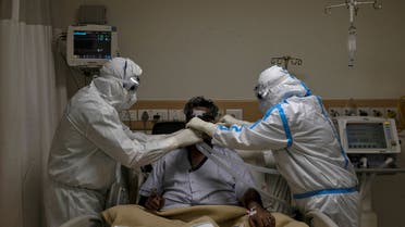 FILE PHOTO: Medical workers wearing personal protective equipment (PPE) take care of a patient suffering from the coronavirus disease (COVID-19), at the Intensive Care Unit (ICU) of the Max Smart Super Speciality Hospital in New Delhi, India, May 28, 2020. REUTERS/Danish Siddiqui/File Photo