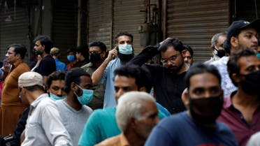 Shopkeepers stand outside a shopping bazar, after police sealed it for not following the government's precautionary measures following the spread of coronavirus disease (COVID-19). (Reuters)