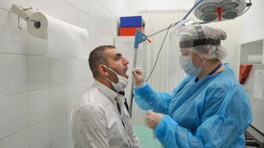 A medical specialist wearing protective gear takes a swab from a man at Sheremetyevo International Airport amid the outbreak of the coronavirus disease (COVID-19) outside Moscow, Russia June 4, 2020. Alexander Avilov/Moscow News Agency/Handout via REUTERS ATTENTION EDITORS - THIS IMAGE HAS BEEN SUPPLIED BY A THIRD PARTY. MANDATORY CREDIT.