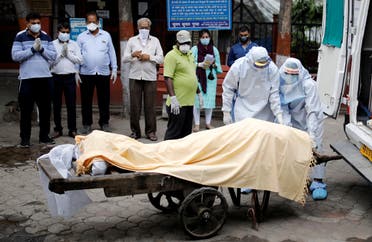 Health workers cover the body of a man who died due to the coronavirus disease (COVID-19), as relatives pay their respects, at a crematorium in New Delhi, India, June 4, 2020. (Reuters)