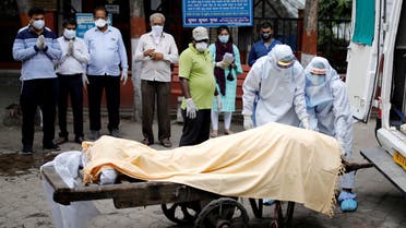 Health workers cover the body of a man who died due to the coronavirus disease (COVID-19), as relatives pay their respects, at a crematorium in New Delhi, India, June 4, 2020. REUTERS/Adnan Abidi