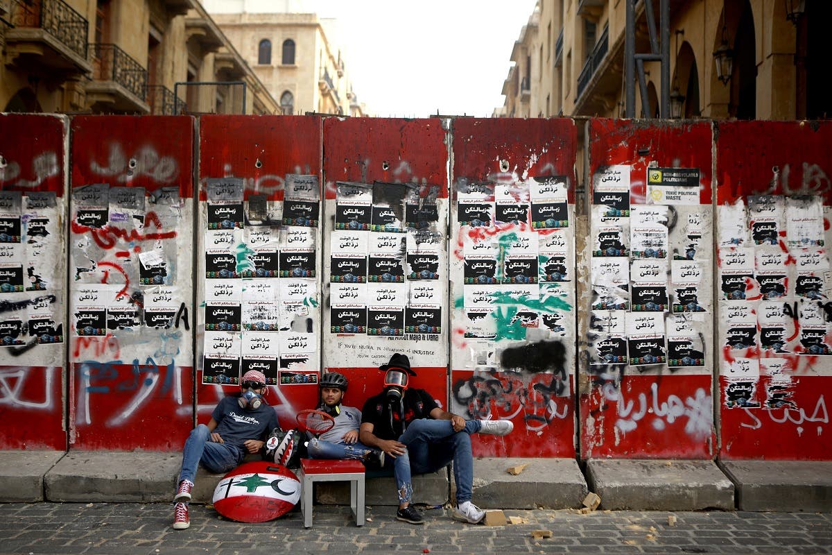 Lebanese protesters sit outside a fortified entrance of the Lebanese parliament during a demonstration in central Beirut on June 6, 2020. (AFP)