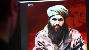 A man looks at a picture of Abdelmalek Droukdel, aka Abu Musab Abdul Wadud, head of Al-Qaeda in the Islamic Maghreb (AQIM) seen on US monitoring group SITE Intelligence. (AFP)