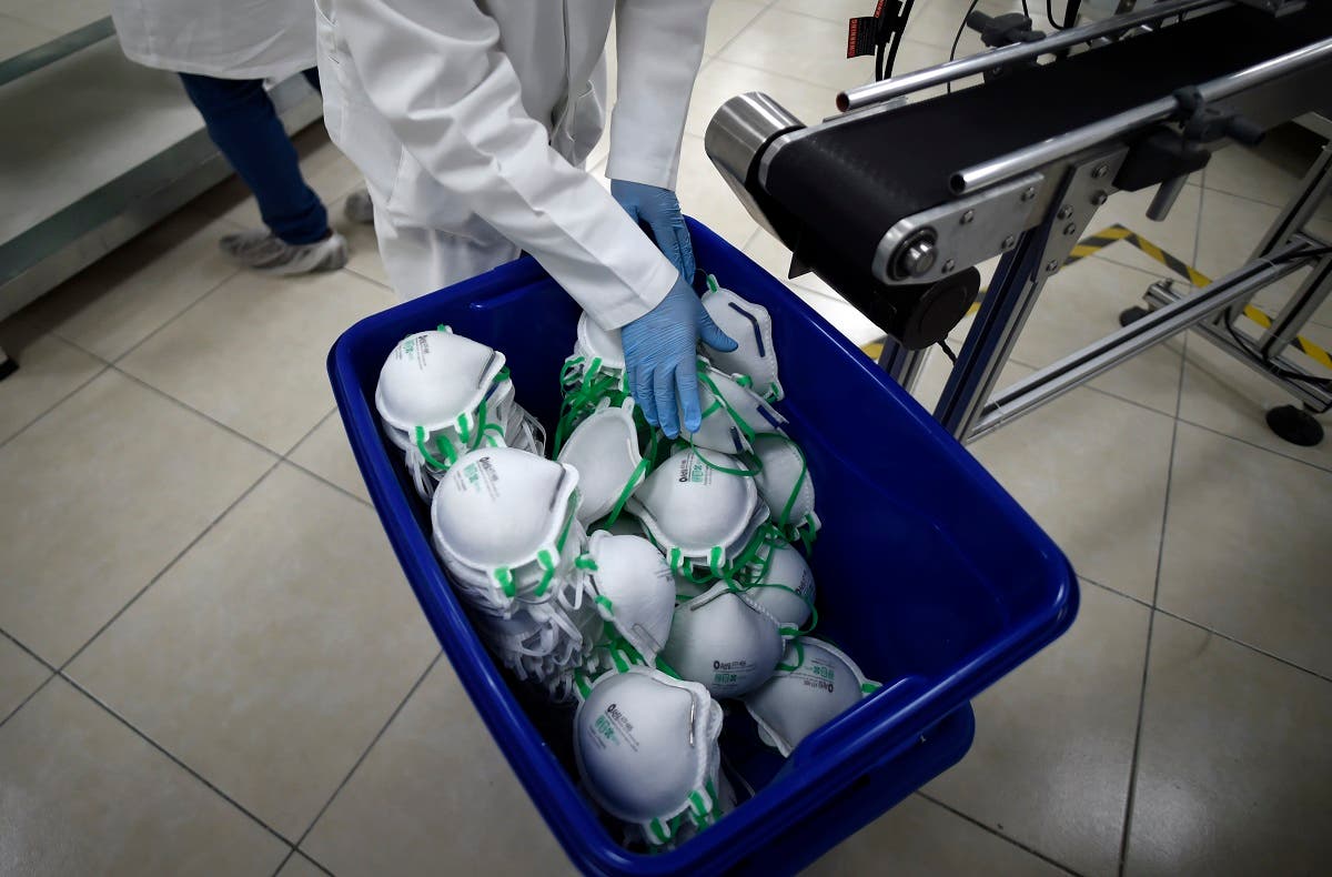 An employee arranges N95 face masks in a box, at a factory that produces 40,000 N95 masks per day, in Mexico City. (AFP)