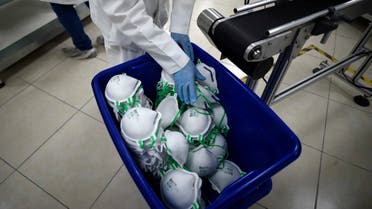An employee arranges N95 face masks in a box, at a factory that produces 40,000 N95 masks per day, in Mexico City. (AFP)