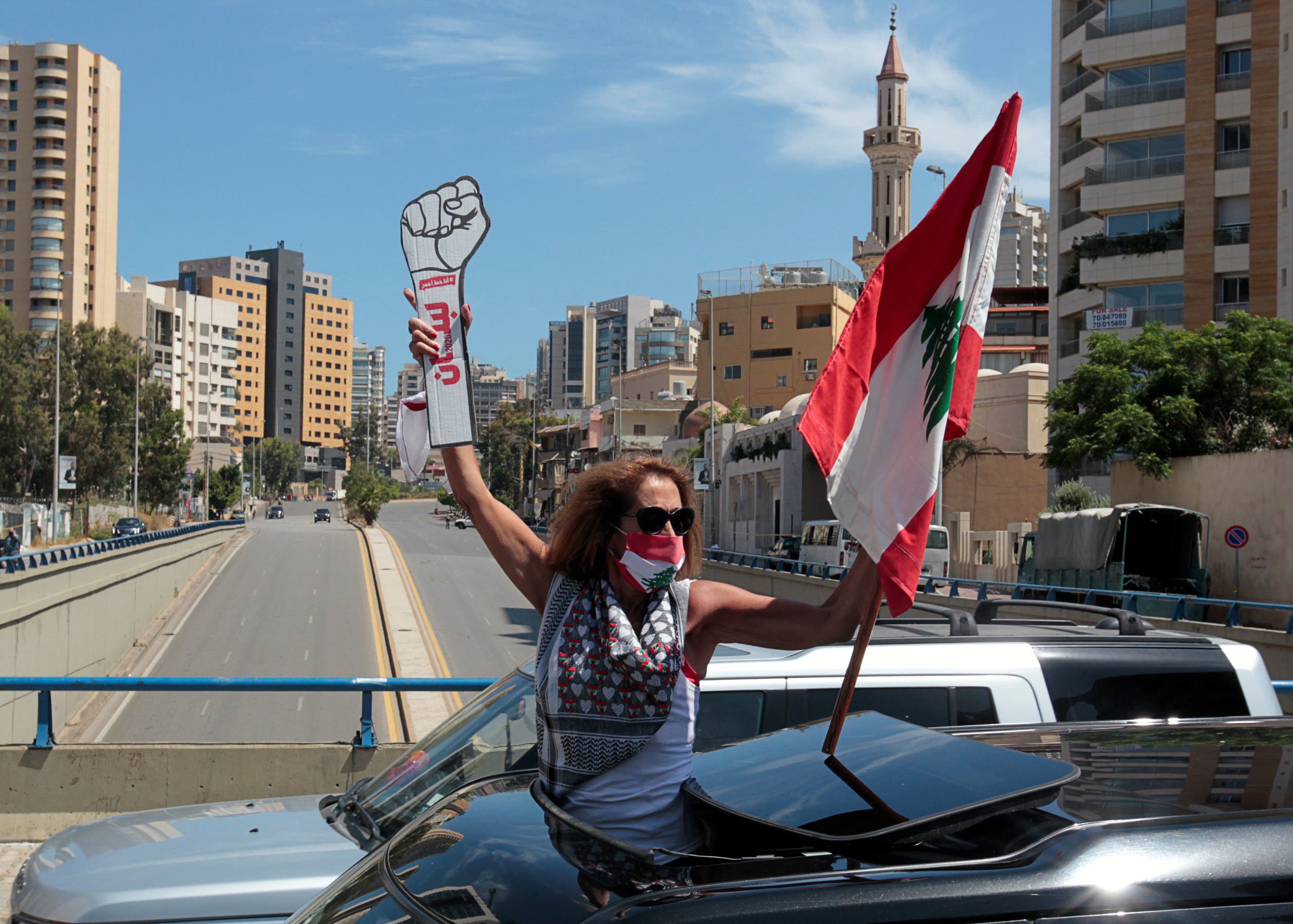 A demonstrator, wearing a mask as a preventive measure against the spread of the coronavirus, carries a national flag during a protest in cars against a controversial amnesty draft law. (File photo: Reuters)