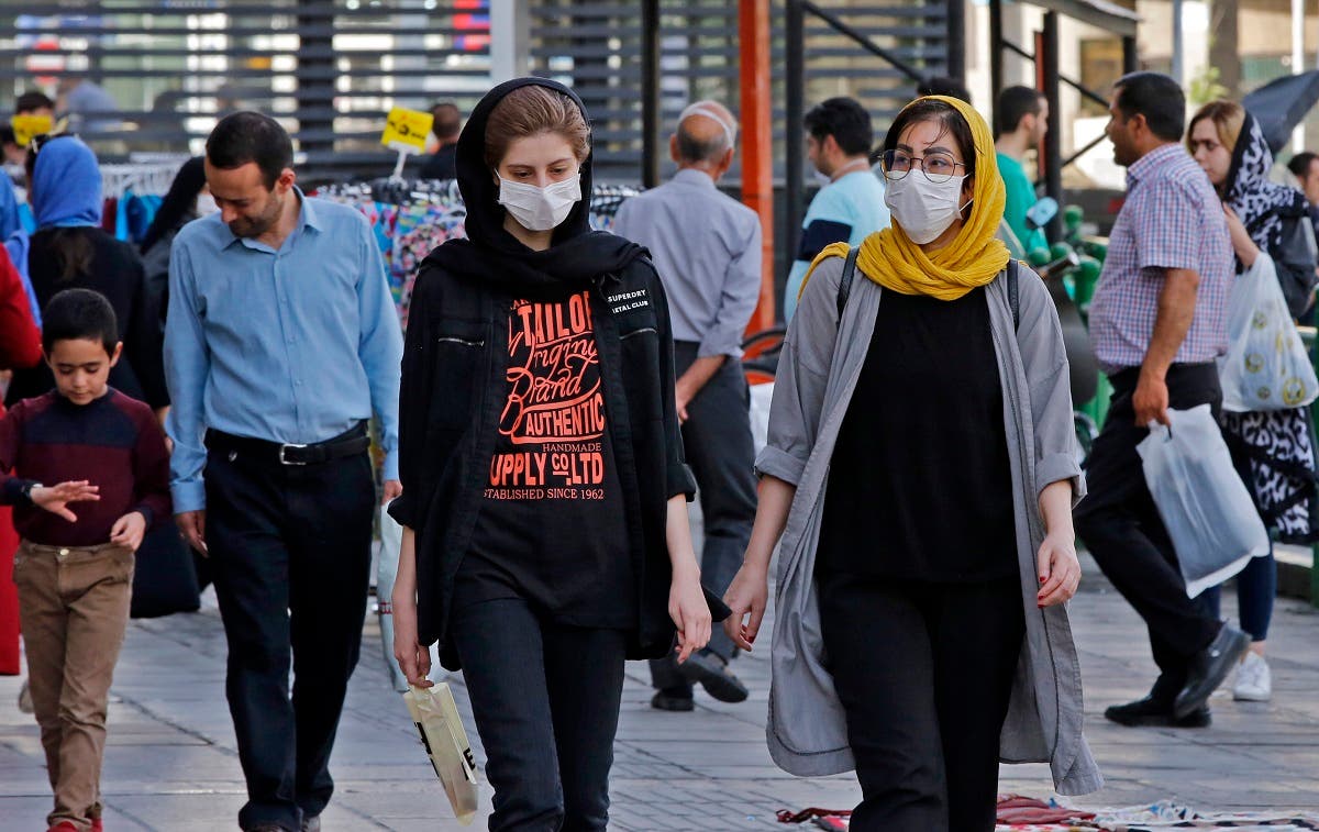 Iranians, some wearing face masks, walk along a street in the capital Tehran on June 3, 2020, amid the novel coronavirus pandemic crisis. (AFP)