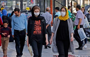 Iranians, some wearing face masks, walk along a street in the capital Tehran on June 3, 2020, amid the novel coronavirus pandemic crisis. (AFP)